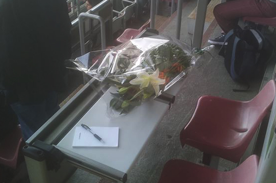 I fiori, la penna e il taccuino nella postazione che era di Marco Ansaldo
