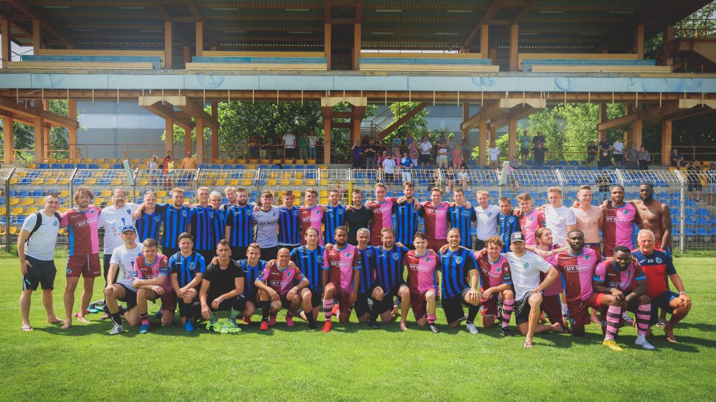 BAK and Corinthian-Casuals players pose for a group photo after the opening game of the inaugural Egri Erbstein Tournament